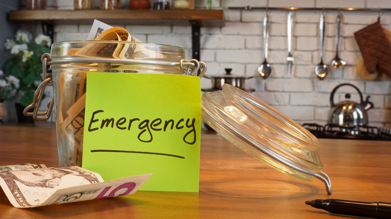 Emergency fund jar full of cash on kitchen counter