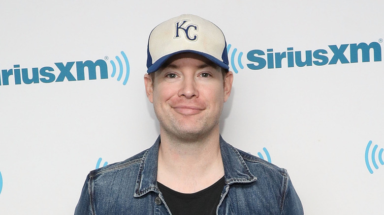 David Cook facing camera smiling while wearing a white and blue hat