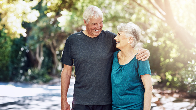 An elderly man and old woman in nature for workout for health benefits, wellness and cardio