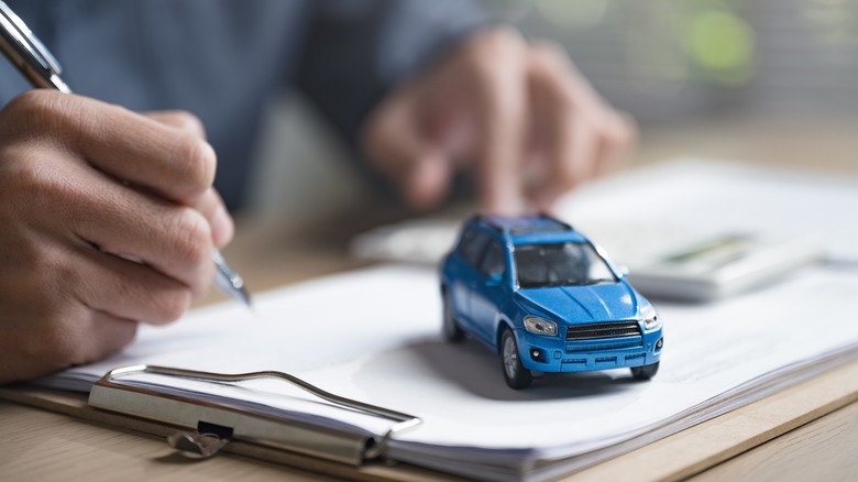 hands calculating data with mini car