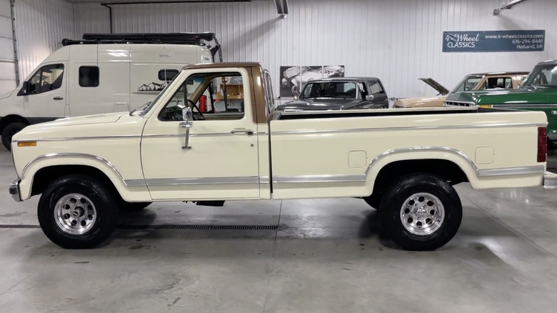 A white 1980 Ford F-150 on display in a garage