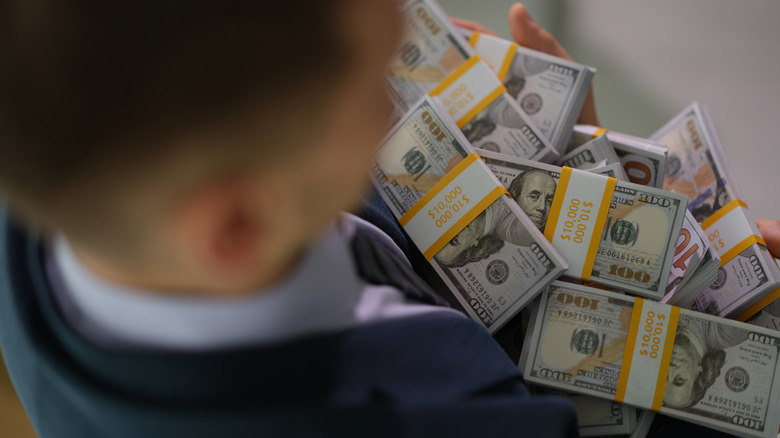 Overhead shot of a person holding stacks of $100 bills