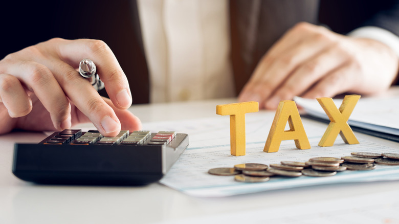 A person using a calculator, perhaps to determine tax obligation