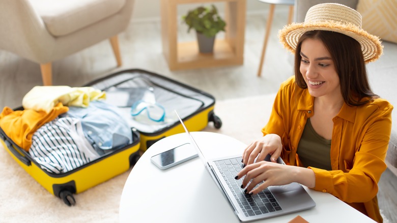 Young woman making travel plans on laptop