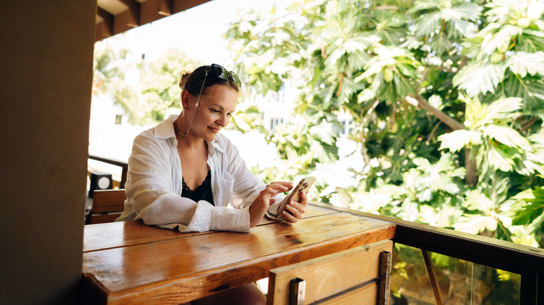 Woman sitting at tables in a sidewalk cafe with an outdoor terrace