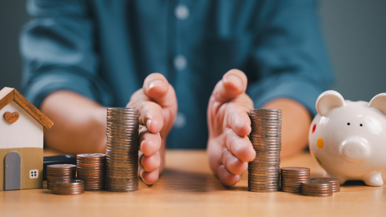 Person dividing money and using hands as barrier.