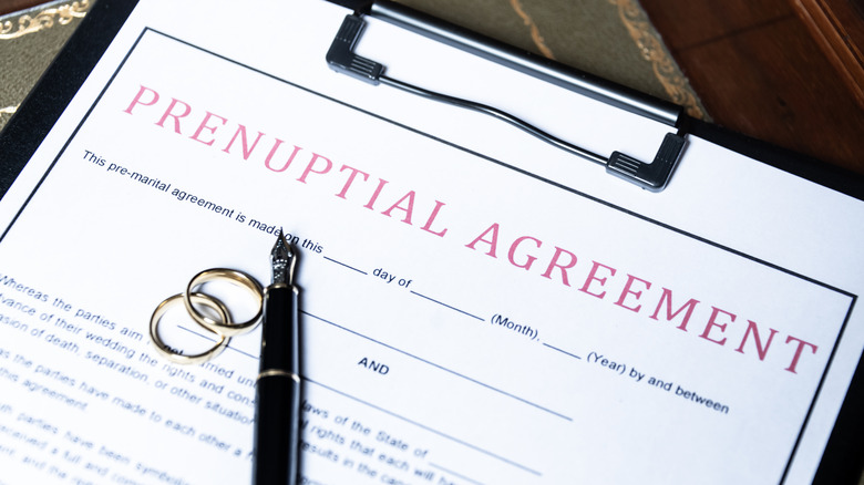 Prenuptual agreement with wedding rings and fountain pen on top
