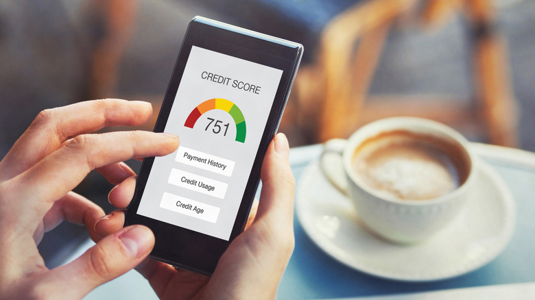 Someone checks their credit score on their phone while out for coffee