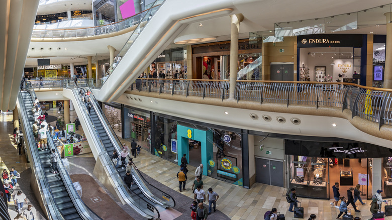 Busy scene with shoppers on escalators inside the Bullring Shopping Mall.