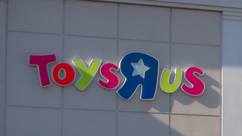 A Toys R Us sign against a beige commercial building facade.