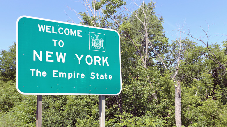 Green road sign saying "Welcome to New York The Empire State."