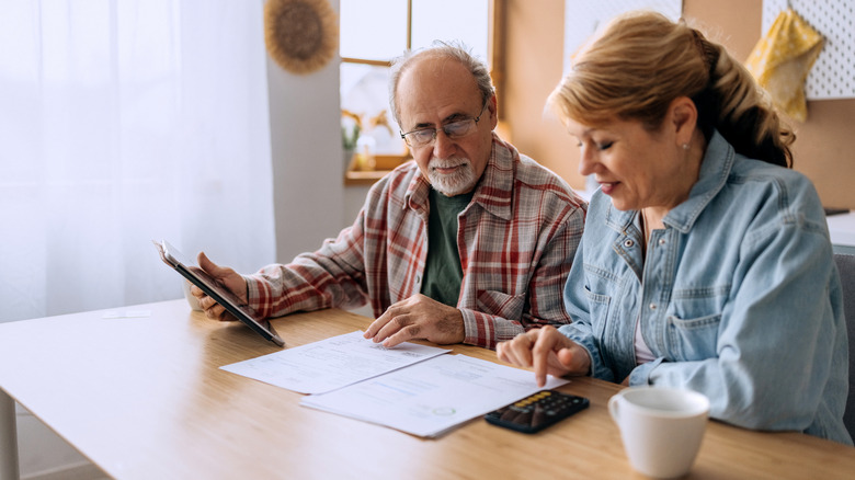 Senior couple looking at financial documents at a table