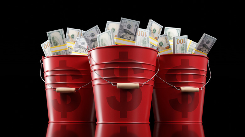 Three red buckets filled with money