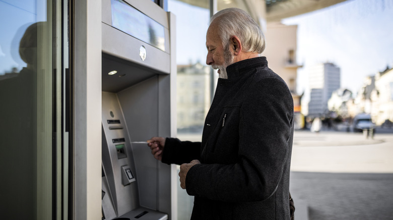 A senior withdrawing cash from an ATM