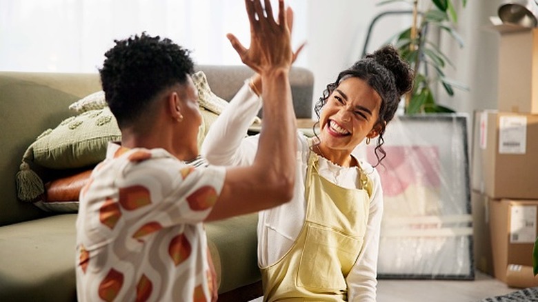 couple high fiving in their new home