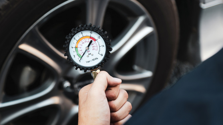 A car mechanic holding a car tire pressure check equipment tool