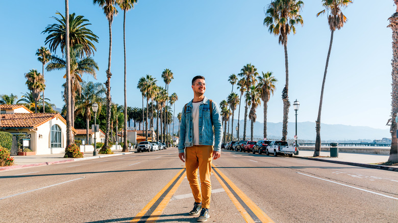 man standing in middle of a California road on sunny day