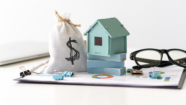 money bag, house figurine, and financial documents