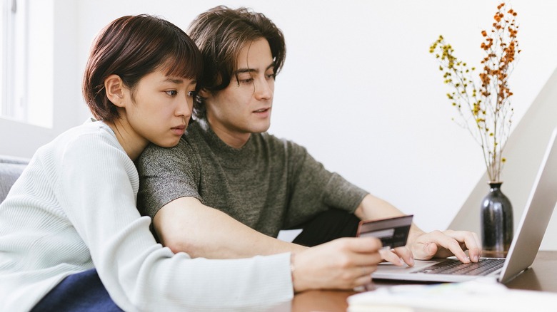Couple looking concerned at laptop