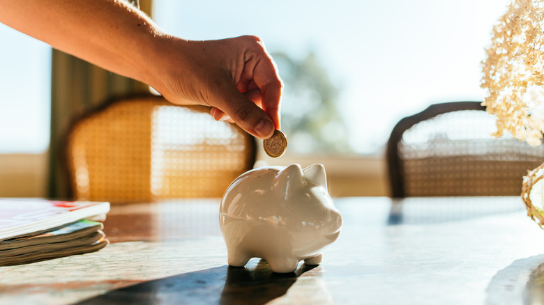putting a coin in a piggy bank
