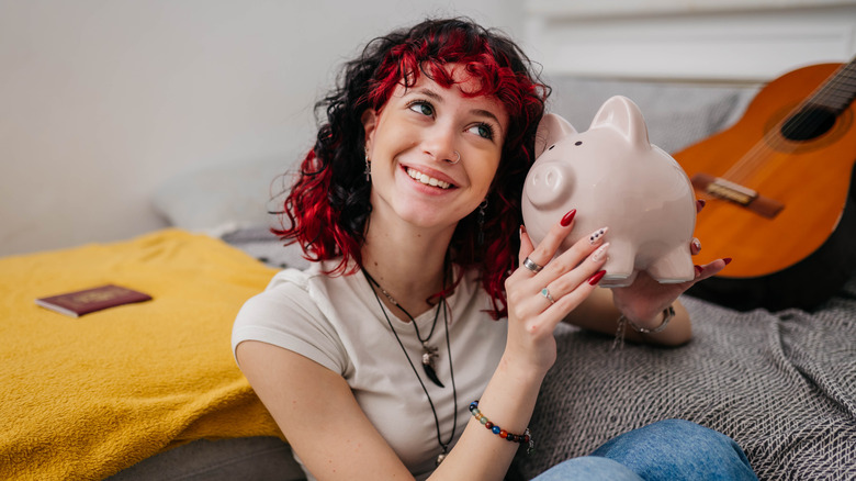 Teen holding piggy bank.