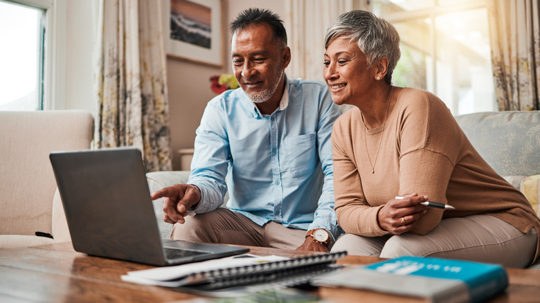 Older couple looking at financial details on a laptop