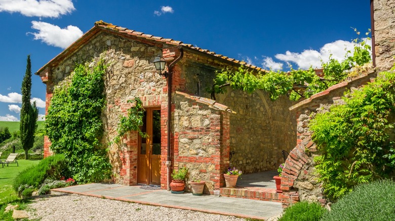 A stone house in a sunny countryside in Italy.