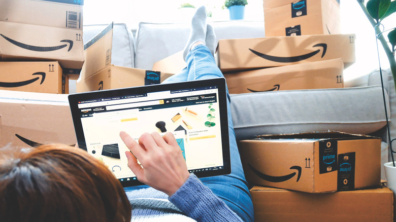A reclining woman resting her feet on Amazon deliveries