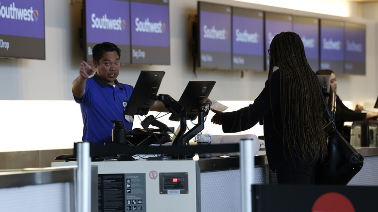 man speaking to woman at southwest check-in counter