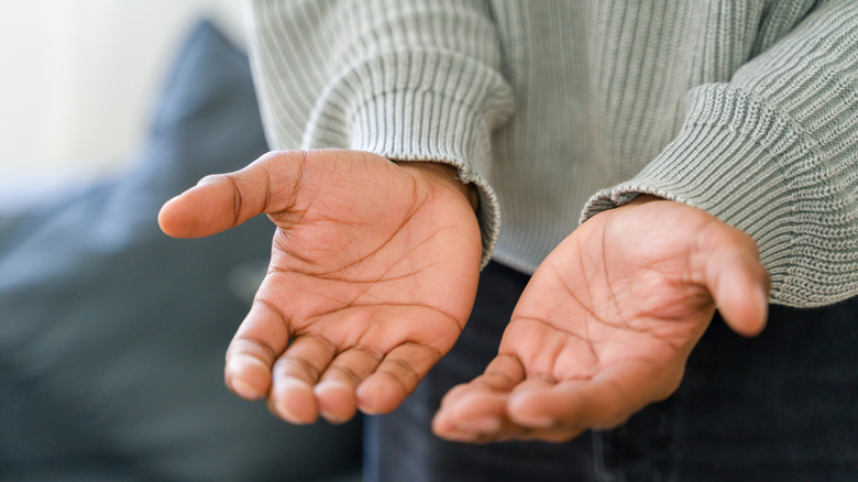 Close up of hands held out in expectation.