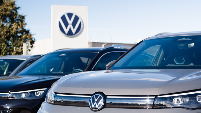 A line of Volkswagen cars parked outside of a dealership