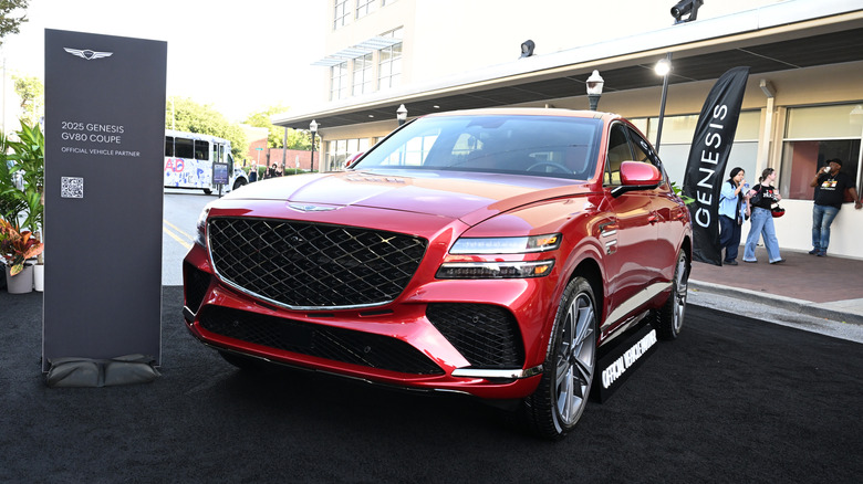 Red Genesis GV80 SUV parked at a dealership