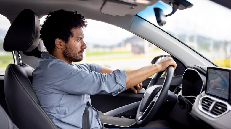 A young man behind the wheel of car