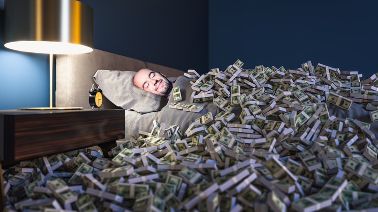 an in bed under a pile of money