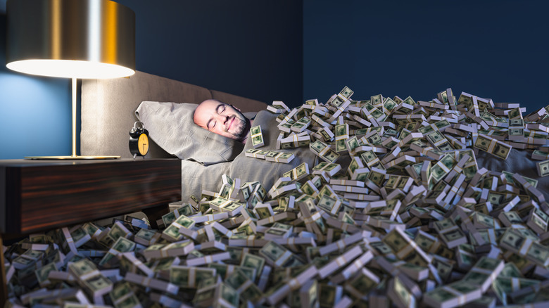 an in bed under a pile of money