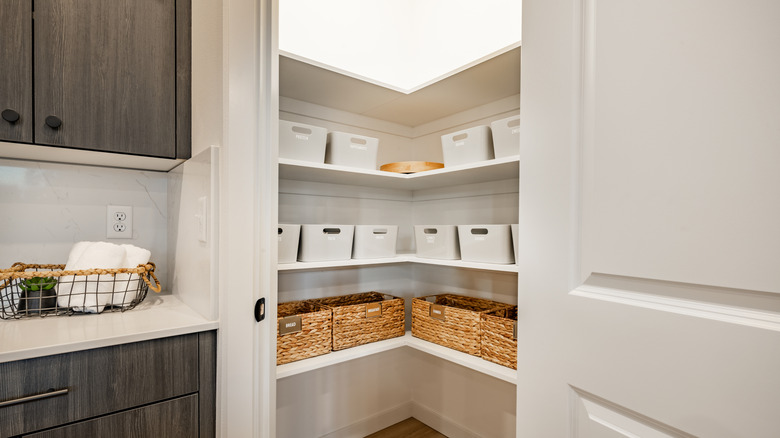 A walk-in kitchen pantry with baskets on the shelves