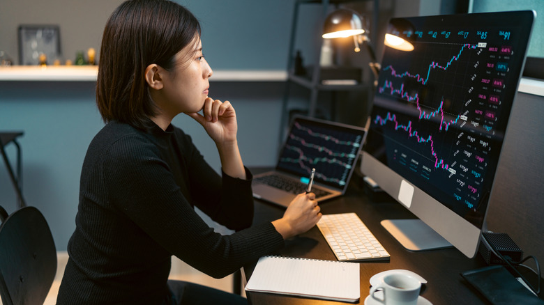 Woman studying stock price charts on a computer screen