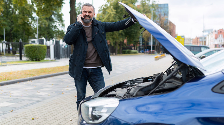 guy on phone with broken car