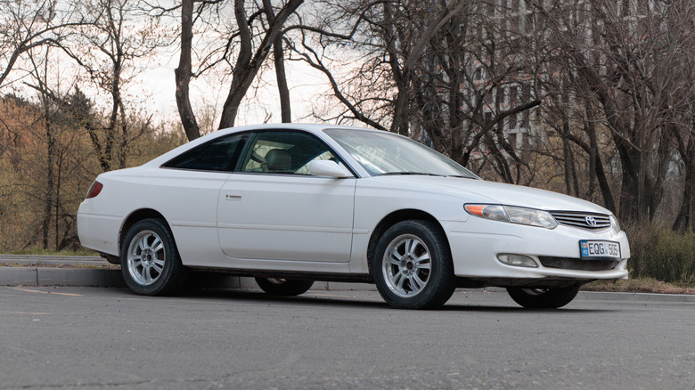A white Camry Solara parked in a parking lot.