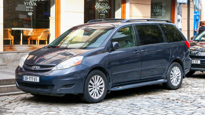 A black Toyota Sienna parked on a city street.