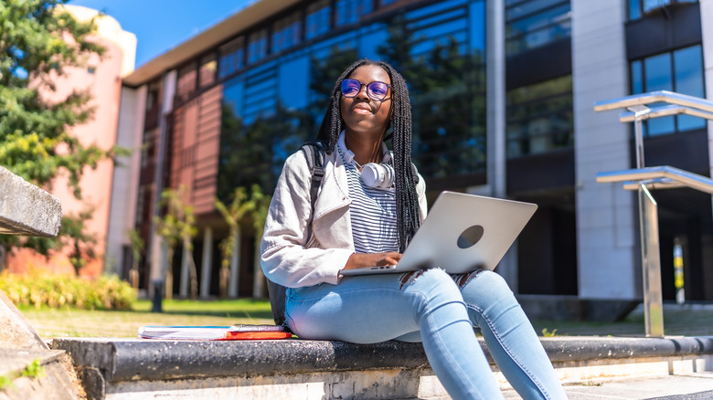 student sitting with her laptop at college