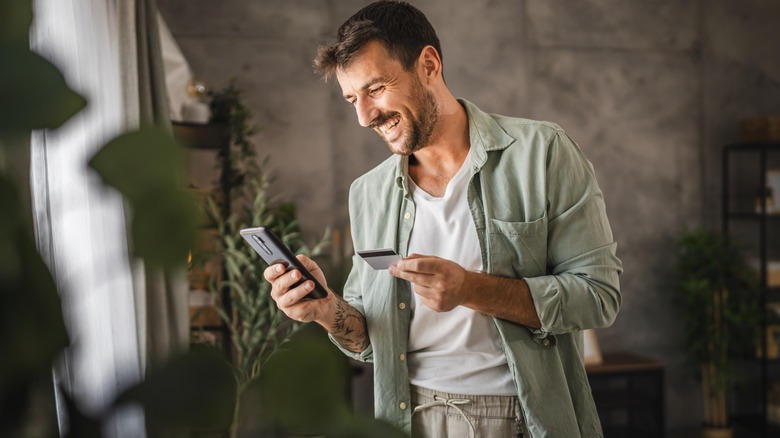 man holding a credit card and smiling