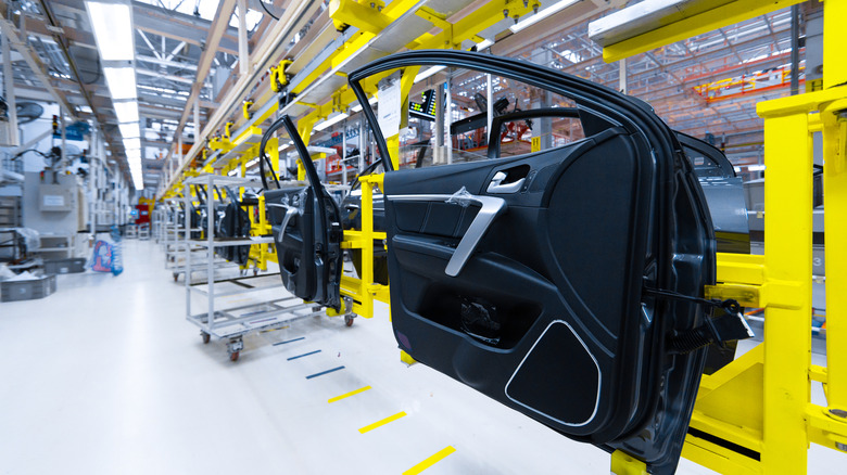 Car doors with finished interior panels moving along an automotive factory assembly line
