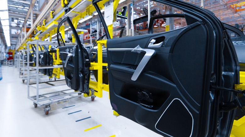 Car doors with finished interior panels moving along an automotive factory assembly line