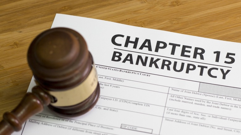 A judge's gavel resting on a U.S. Bankruptcy Court form labeled "Chapter 15 Bankruptcy" on a wooden desk