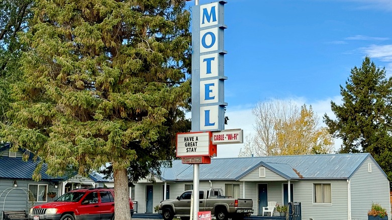 a small motel with two trucks parked out front