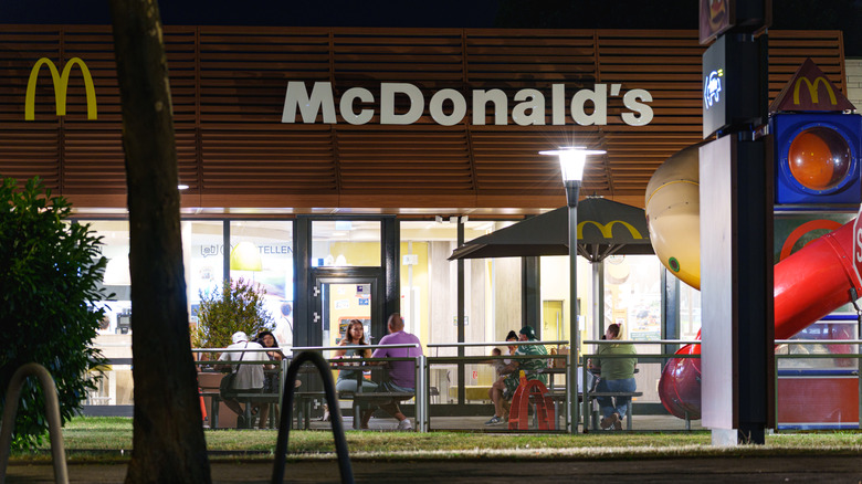 Customers eating outside of a McDonald's location at night