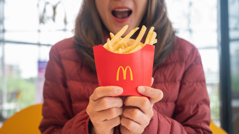 A woman holding McDonald's fries