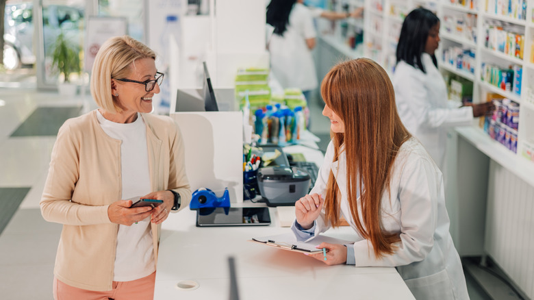 A pharmacist helping a senior citizen customer at counter