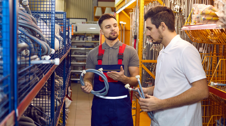 A young man discussing options with a hardware store employee